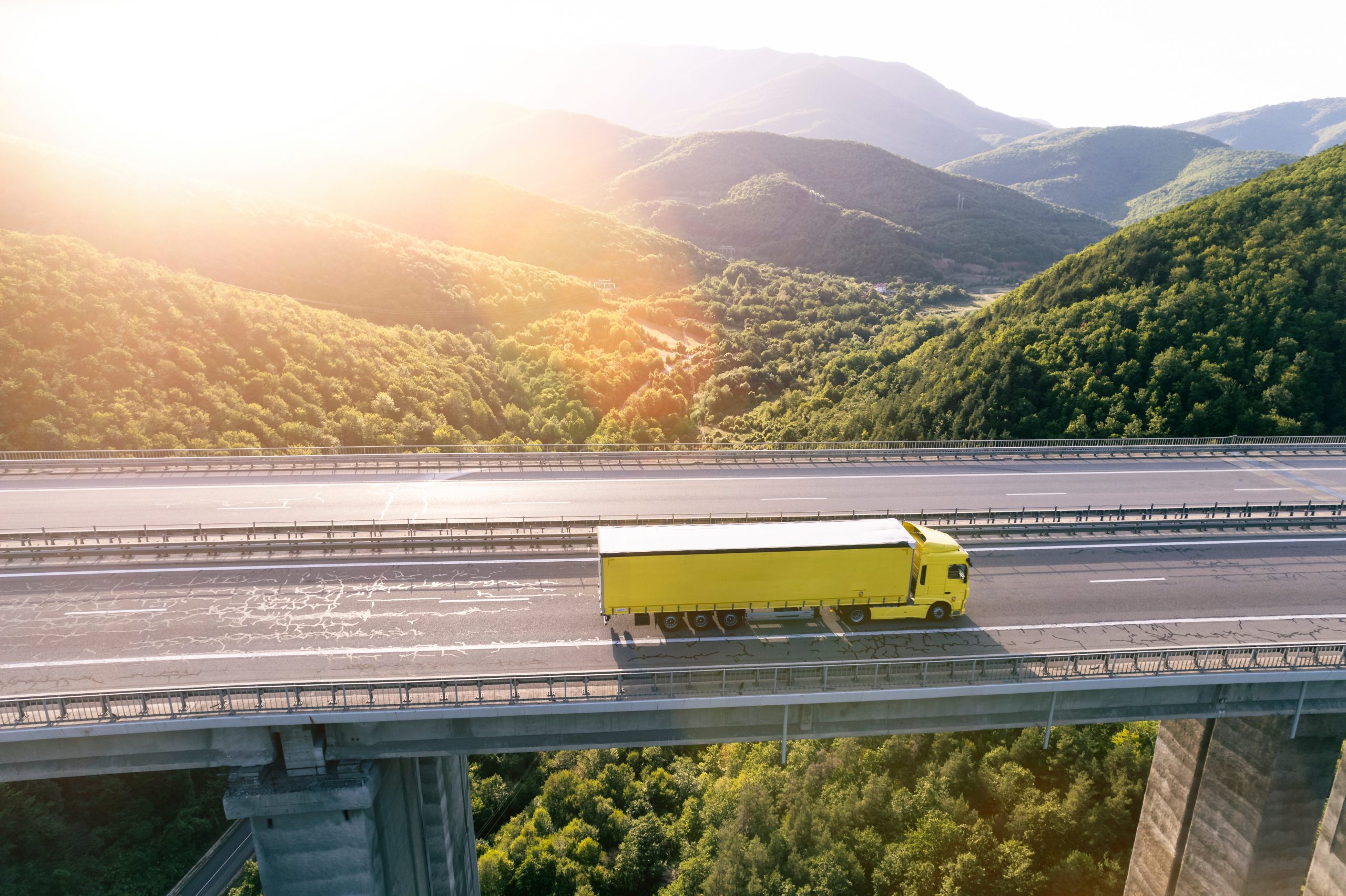 yellow-cargo-delivery-truck-drive-on-highway-aeria-2021-11-19-17-42-30-utc